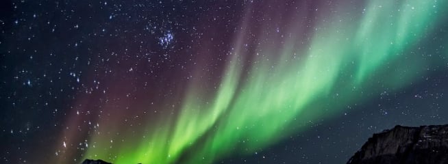 A stunning display of the Northern Lights, with vibrant green and purple hues illuminating the sky.